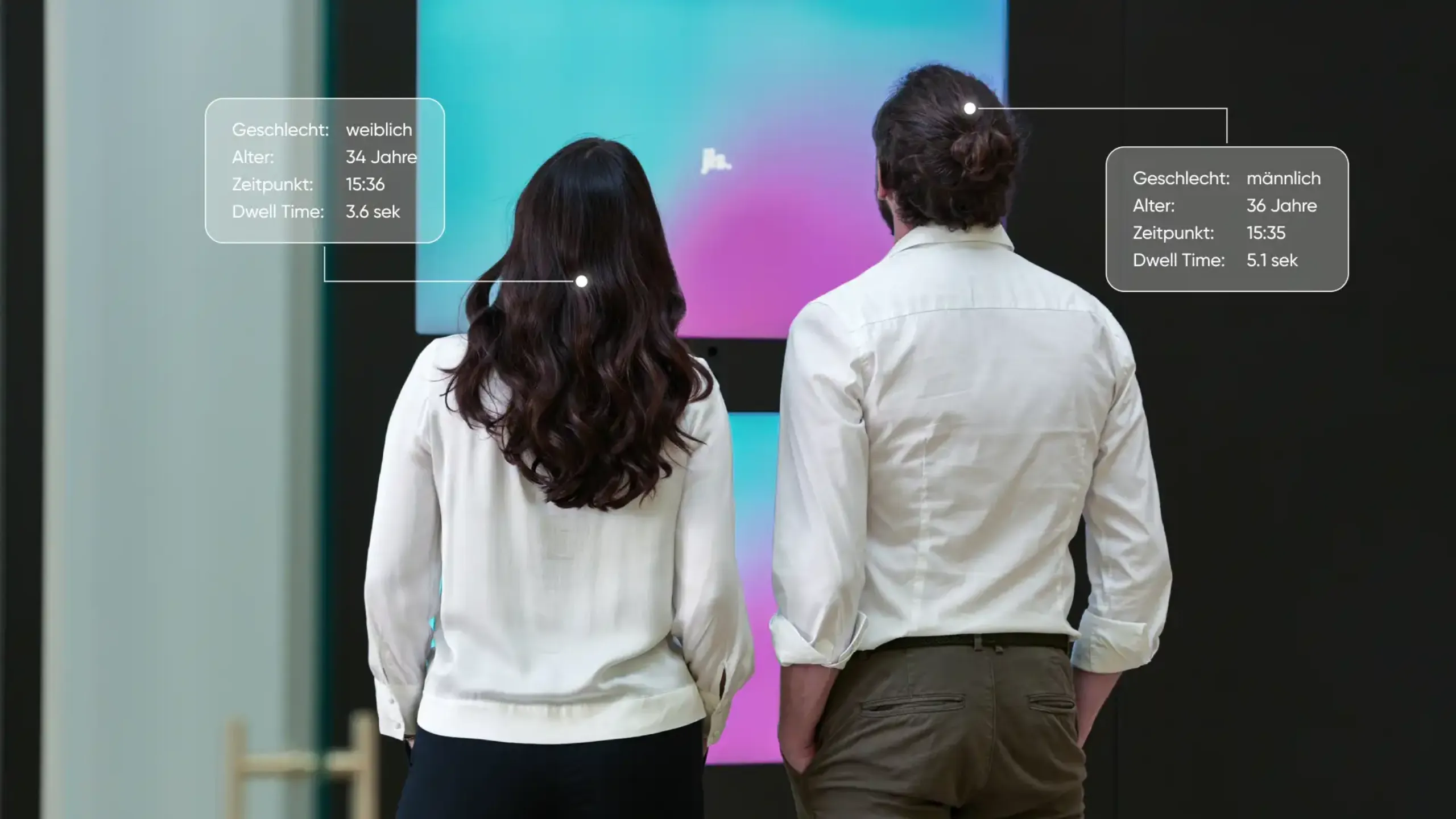 A woman and a man stand in front of a digital signage screen and are analysed based on insights; their gender, age and dwell time are detected.
