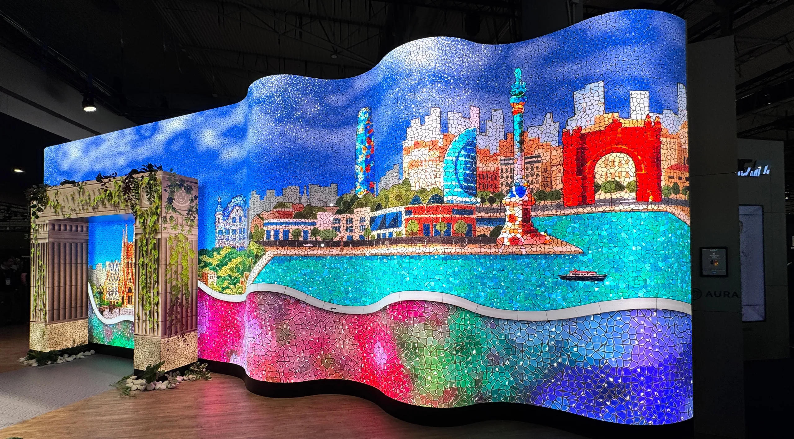Geschwungenes LED-Display (COB-LED) mit farbenfroher Stadtlandschaft auf der ISE 2026 Barcelona.