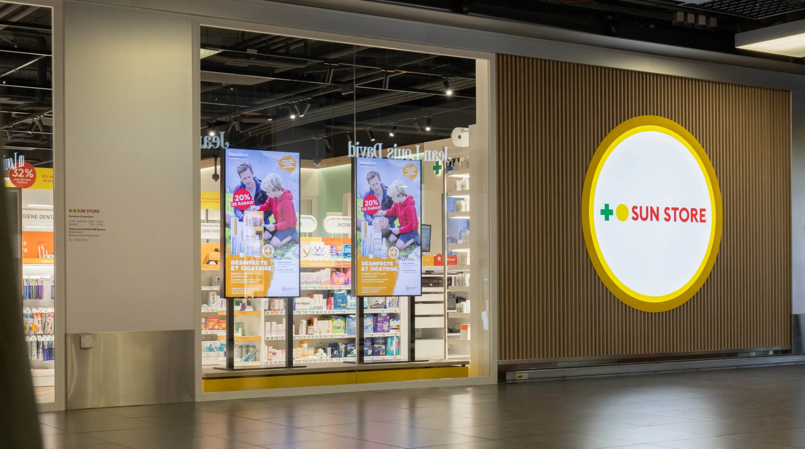 Sun Store Eingangsbereich in Renens mit rundem Digital-Signage-Screen und Wandmodulen