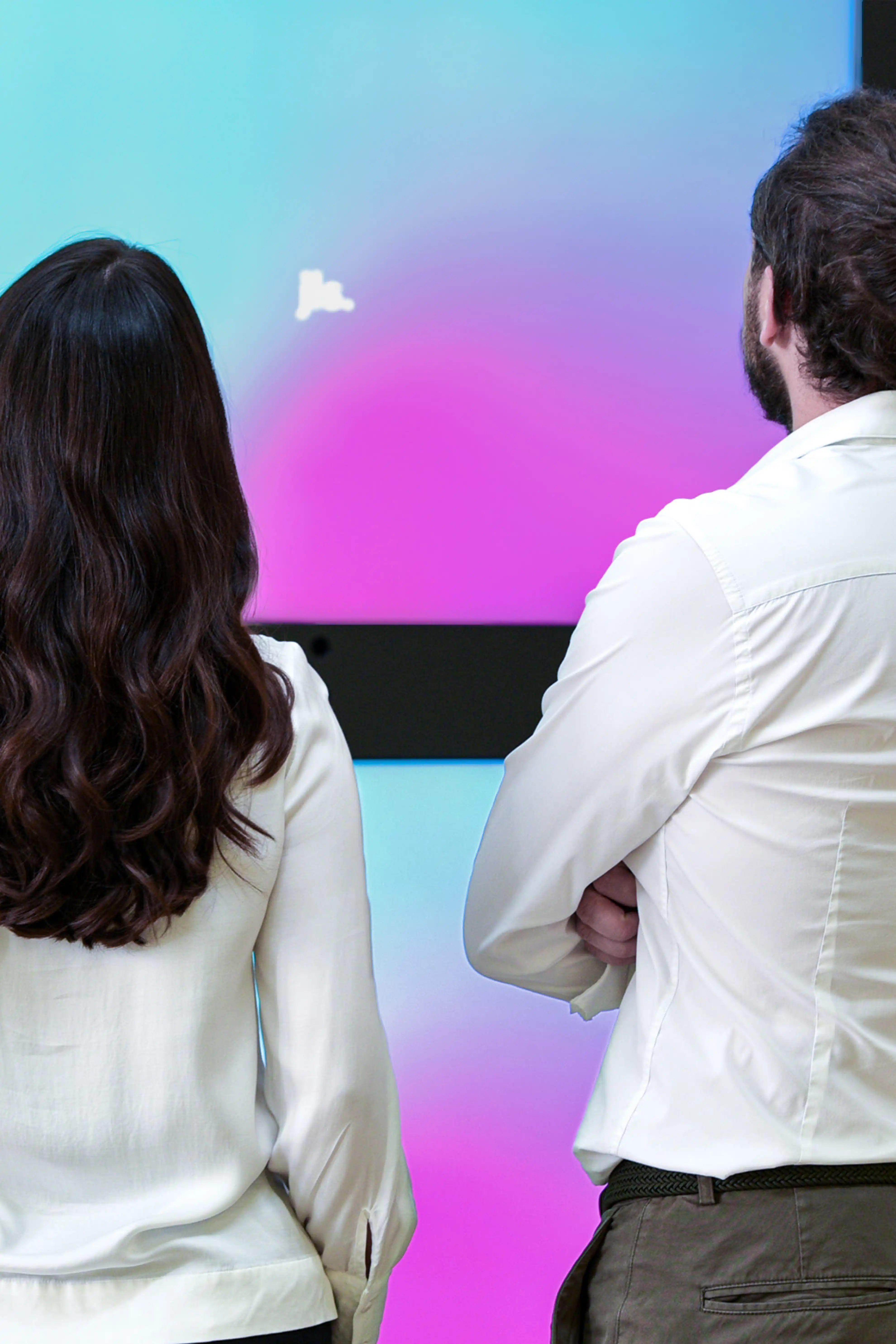 Menschen schauen auf Screen-Wand mit Bewegtbild