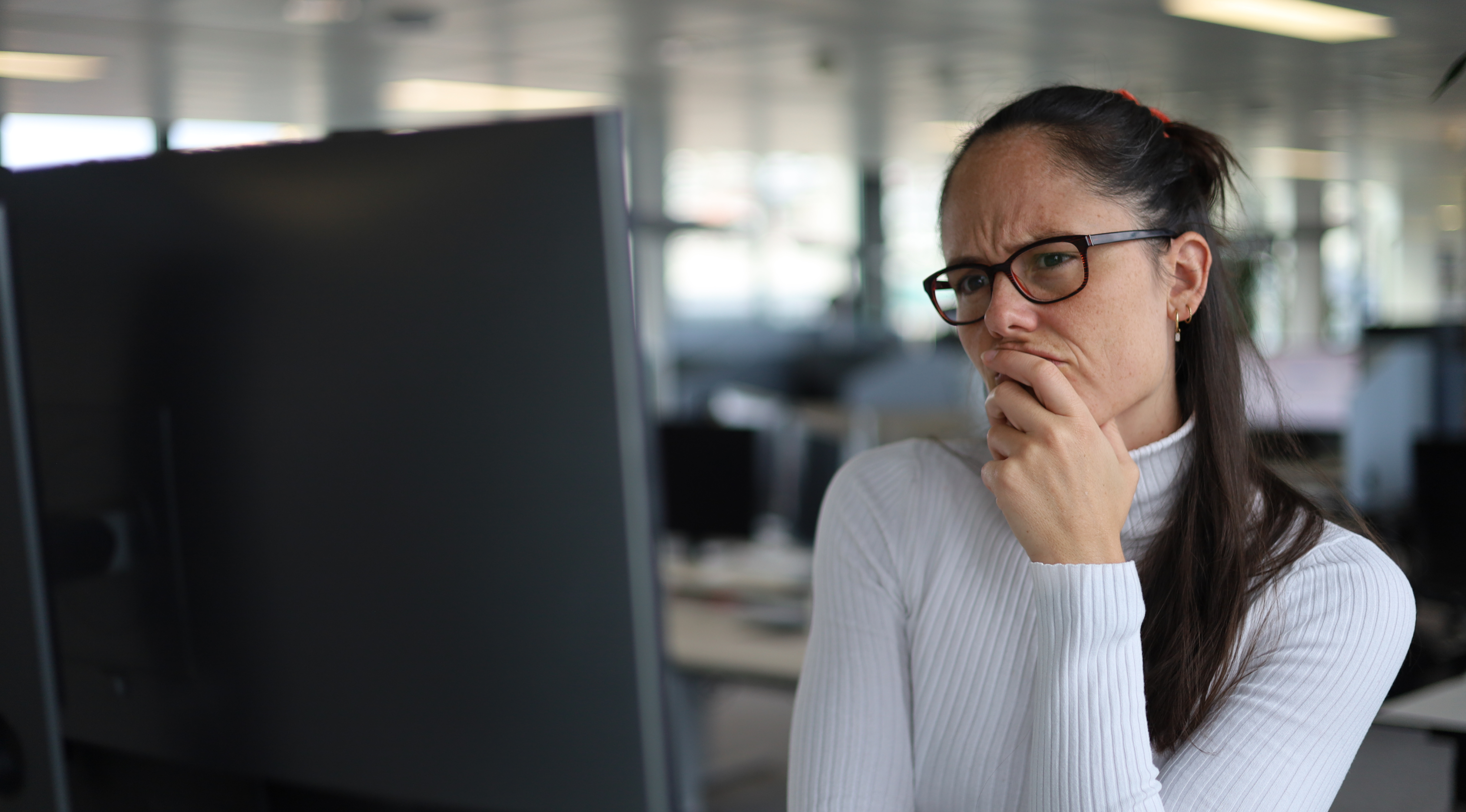 Thoughtful person at a screen – hybrid interfaces combining AI and UX for modern customer interaction.