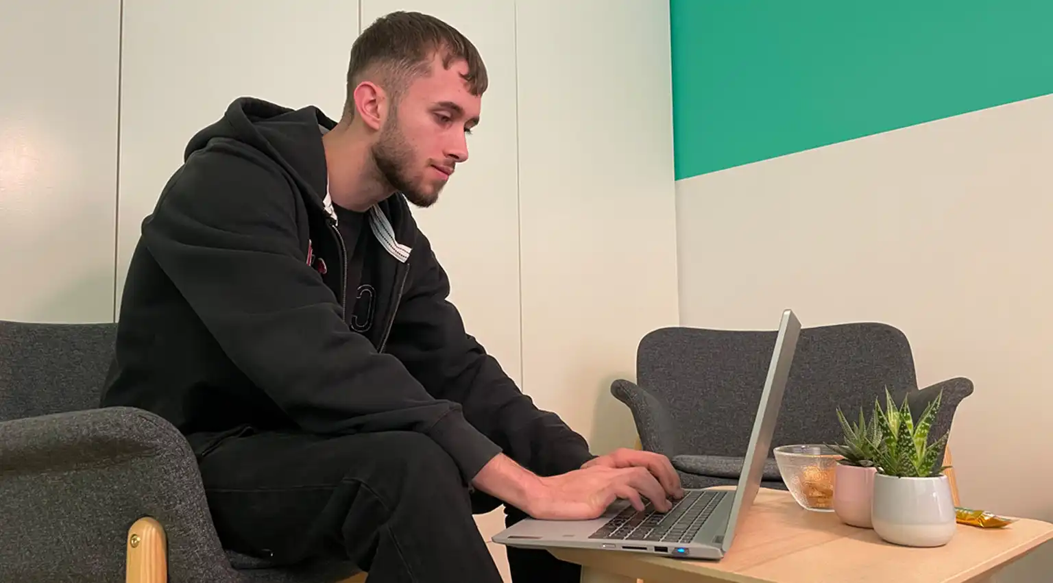 Junge Person arbeitet am Schreibtisch mit Laptop und Dokumenten – Symbolbild für die KV-Ausbildung bei jls