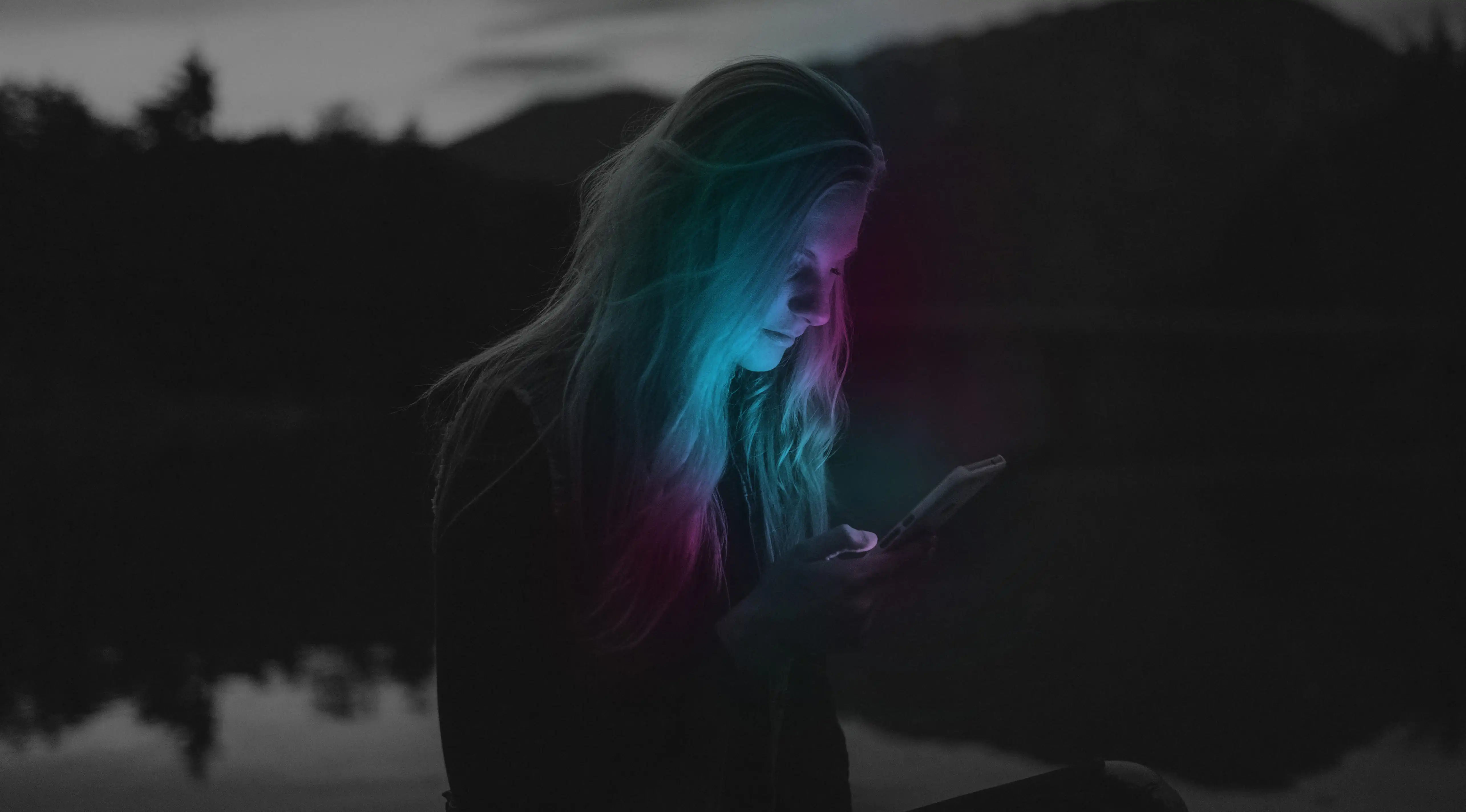 Woman illuminated by mobile phone screen
