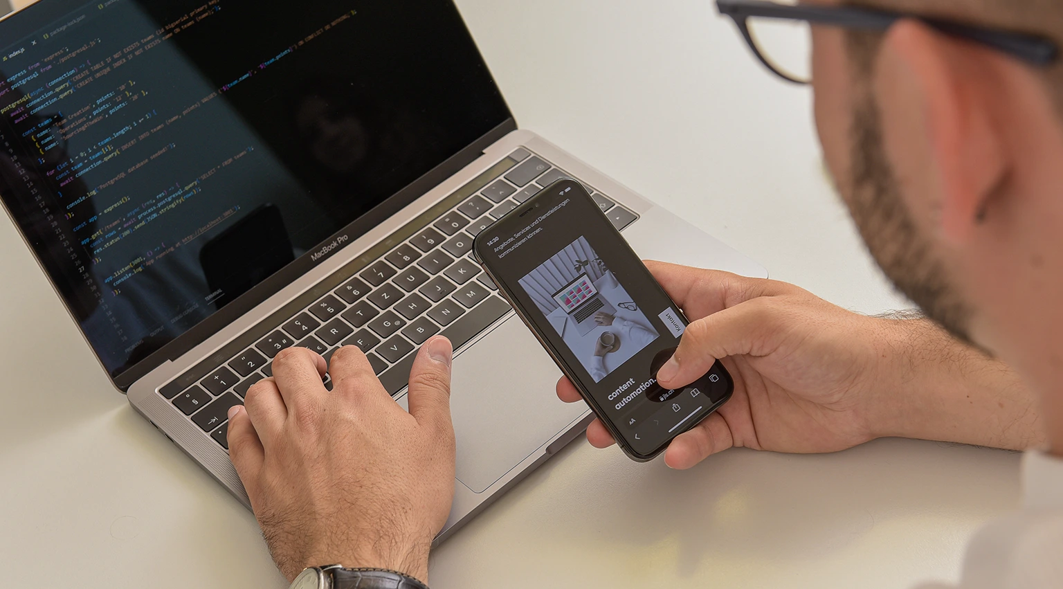 jls Content Automation im Workflow: Smartphone-Review und Laptop mit Code für skalierbare Content-Produktion.