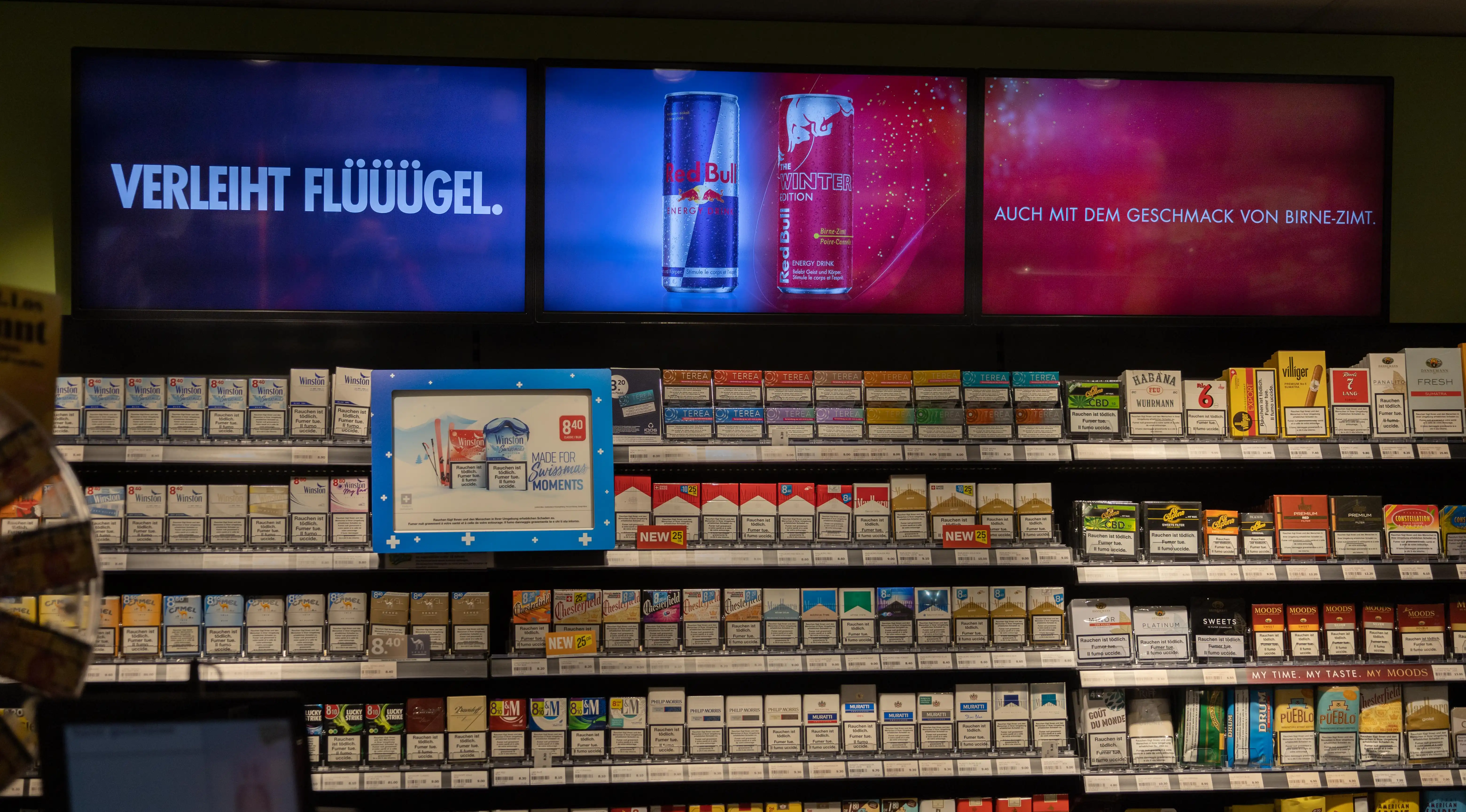 Redbull content on digital signage checkout module above tobacco offer
